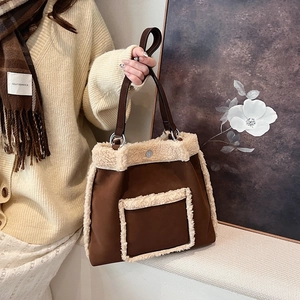 Brown suede shoulder bag with cream faux fur trim and leather straps for winter style