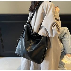 Detail der schwarzen Hobo-Tasche aus Kieselleder mit V-Nähten und breitem Schultergurt