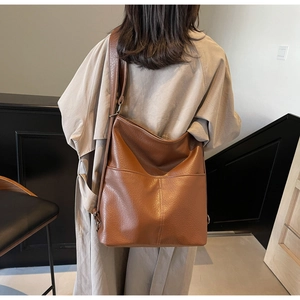 Braune Ledertasche mit breitem Gurt an einem Model für einen stilvollen Look
