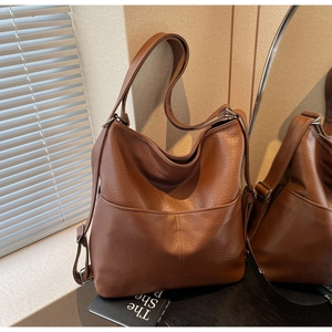 Makro-Detail des braunen Leders mit Litschi-Muster und silberner Metallschnalle der Tasche