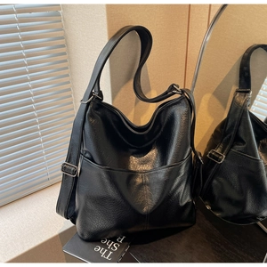 Detail der schwarzen Hobo-Tasche aus genarbtem Leder mit großer Fronttasche und Silberbeschlägen