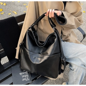 Detailansicht einer schwarzen Shopper-Tasche aus Leder mit breitem Gurt am Außenmodell