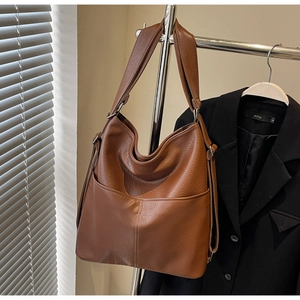 Detail der braunen Kunstledertasche mit Lychee-Struktur und großer Fronttasche