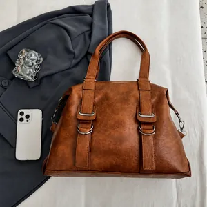 Close-up of vintage brown PU leather handbag texture with silver metal buckles