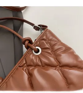 Détail du sac cabas matelassé caramel avec œillets argentés et coutures de précision