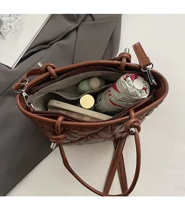 Vue de dessus d'un sac matelassé marron montrant sa grande capacité et son rangement