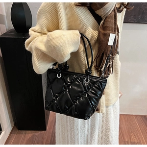 Détails du sac seau noir matelassé avec poignée nouée et œillets métalliques argentés