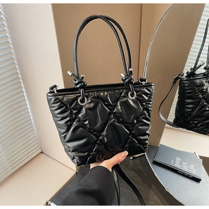 Détails du sac matelassé noir avec poignées rondes et œillets métalliques argentés