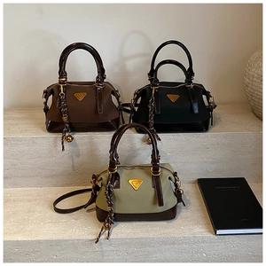 Drei Boston-Taschen aus Nylon und Lackleder in Braun Schwarz und Grün auf Steinstufen