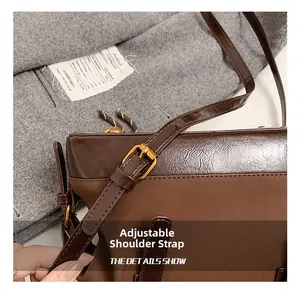Nahaufnahme des verstellbaren Riemens mit Gold-Schnalle an einer braunen Ledertasche