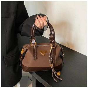 Detail der dunkelbraunen Boston-Tasche mit mattem und Lackleder sowie goldenem Dekor