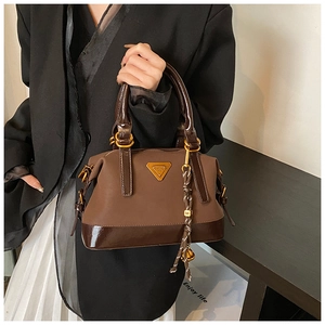 Detail der Vintage-Patchwork-Handtasche mit Bronze-Metallbeschlägen und M-Anhänger