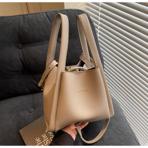 Detail view of beige lychee grain leather bucket bag with HAMIROO embossed logo