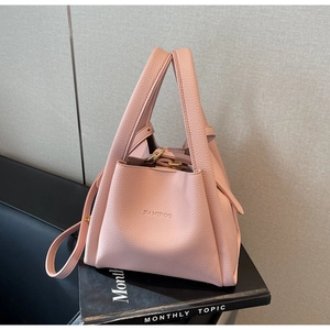 Detail of pink lychee grain leather bucket bag with top handles and HAMIROO logo