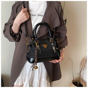 Modische schwarze Handtasche aus Nylon mit Lacklederbesatz und goldenem Dreiecksdetail