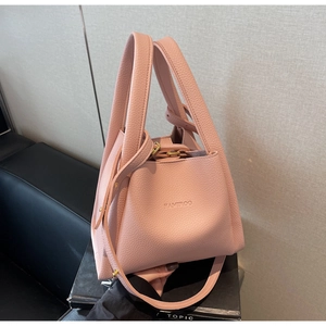 Detail of pink lychee leather bucket bag with top handle and gold fastevers