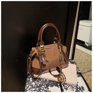 Detail der Vintage-Handtasche aus Canvas und Lackleder mit Goldlogo und Quastenanhänger