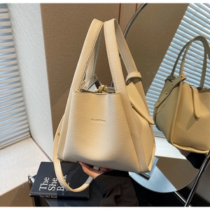 Detail of cream lychee leather bucket bag with geometric folds and HAMIROO logo