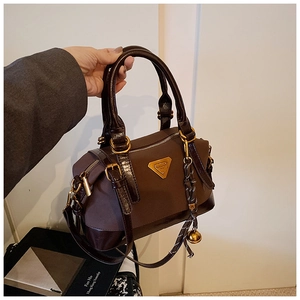Detail der Vintage-Tasche aus dunkelbraunem Glanzleder mit Canvas und Gold-Logo