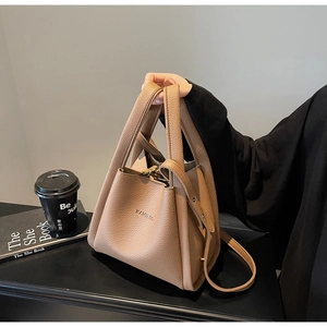 Close-up of brown litchi pattern leather bucket bag with embossed logo and handle
