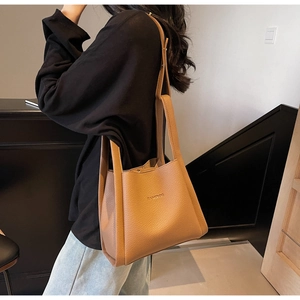 Detail of caramel bucket bag with pebble leather texture and BAMBOO embossed lettering