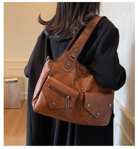 Detailansicht einer braunen Vintage-Einkaufstasche aus PU-Leder mit mehreren Taschen
