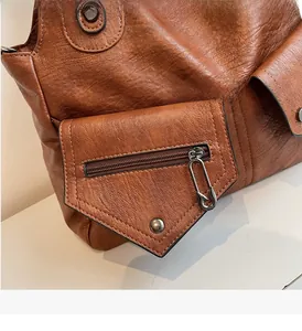 Detail der vintage karamellfarbenen Ledertasche mit Narbung und Sicherheitsnadel-Zipper