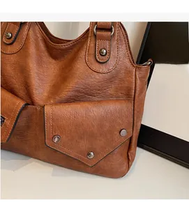Detailaufnahme der braunen Vintage-Tasche aus Kunstleder mit silbernen Nieten
