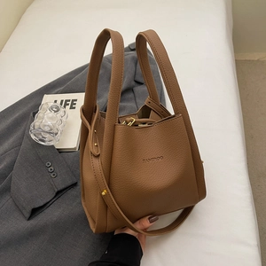 Brown litchi grain leather bucket bag with top handles and a detachable shoulder strap