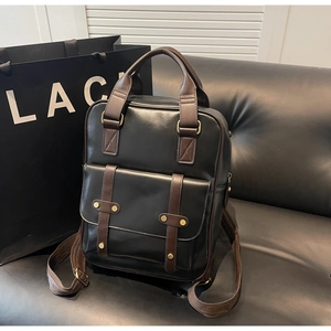 Detail of vintage faux leather backpack featuring black and brown contrast and metal buckles