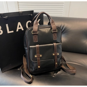 Detail of classic leather backpack showing brown straps, flip cover, and brass buckles