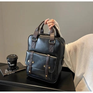 Detail of vintage leather backpack with contrast brown straps and metal buckle closure