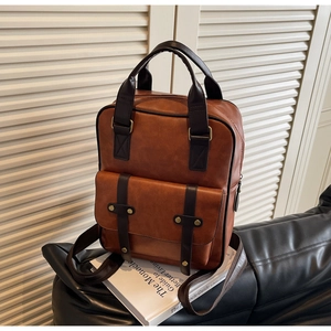 Detail view of vintage brown PU leather backpack with sturdy handle and brass metal buckles