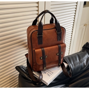 Detail of vintage brown faux leather backpack with bronze buckles and adjustable straps