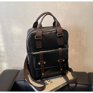 Detail view of vintage contrast leather backpack showing golden hardware and strap stitching