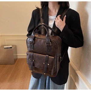 Detailed view of vintage dark brown faux leather backpack with double buckle front pocket