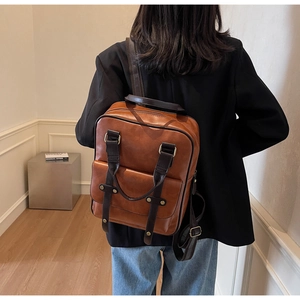 Rear view of model wearing a vintage brown leather backpack with adjustable straps