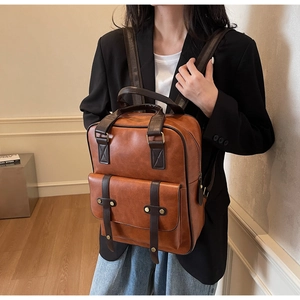 Close-up of retro brown PU leather backpack featuring vintage metal buckles and texture