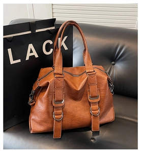 Close-up of the textured brown soft leather tote bag with dark grey metal D-ring buckles