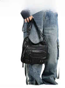 Detail of vintage black washed leather crossbody bag with tassel zippers and metal studs