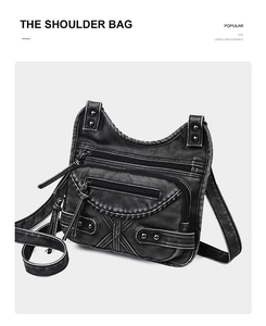 Detail of vintage black washed leather shoulder bag with functional zippers and studs