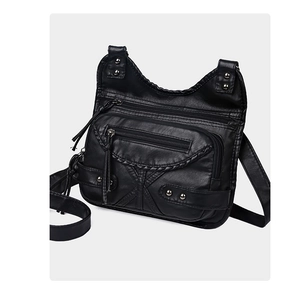 Detail of vintage washed leather crossbody bag with multiple zippers and rivets