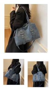 Detail view of large blue leather tote bag with metallic rings and vertical straps