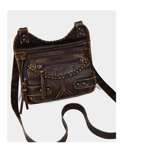 Detail of vintage brown leather crossbody bag with triple zippers and metallic rivets