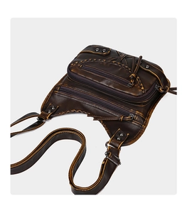 Detail of vintage brown punk crossbody bag with multiple zip pockets and metal rivets