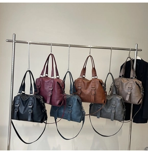 Selection of large leather tote bags in various colors hanging on a metal display rack