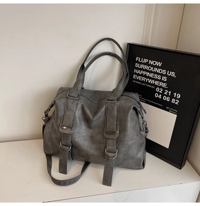 Detail of grey retro tote bag showing leather texture and metallic D-ring hardware