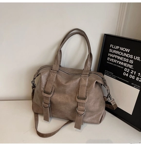Detail view of large dark taupe tote bag with matte leather texture and metal D-rings
