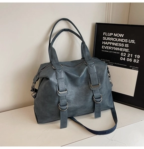 Detail of matte blue tote bag showing textured PU leather surface and silver metal rings