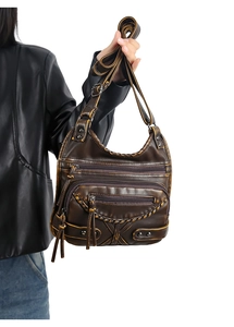 Close-up of vintage dark brown washed leather bag with multi-pocket design and woven edges
